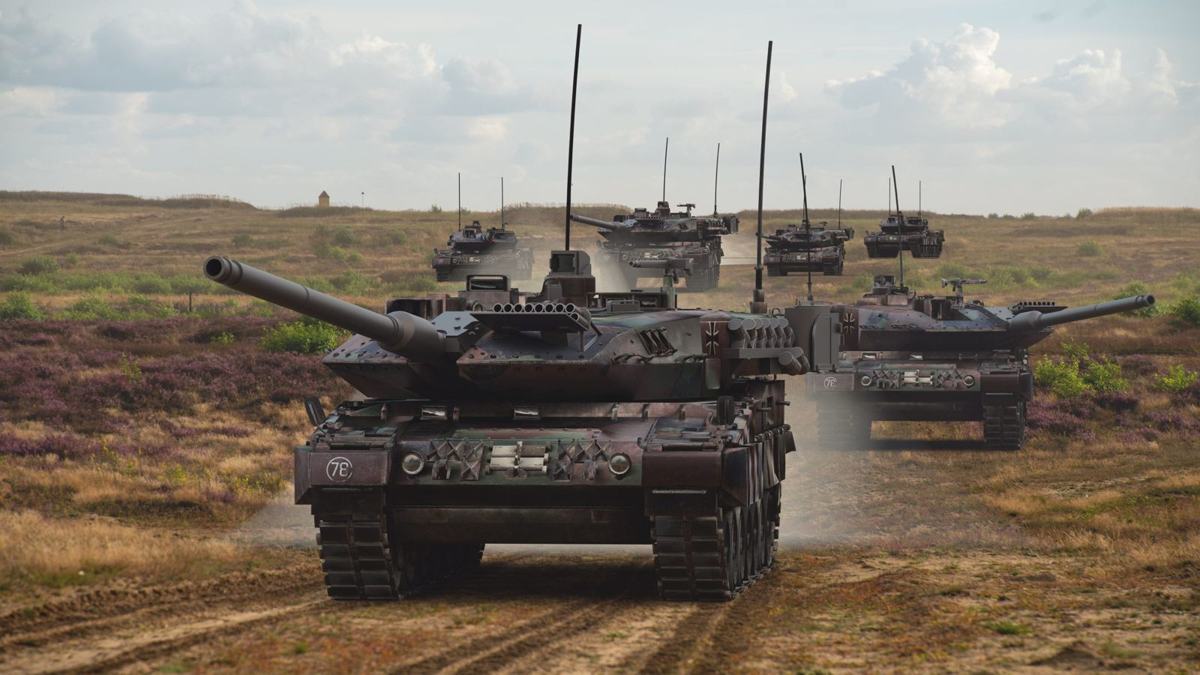 Leopard 2 tanks advancing across a training area